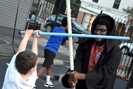 The Boston Lightsaber Stage Combat Club performed and led a workshop outside East Cambridge Savings Bank on Aug. 8, 2019, for the Inman Square Movie Night during the Cambridge Arts Summer In The City series.