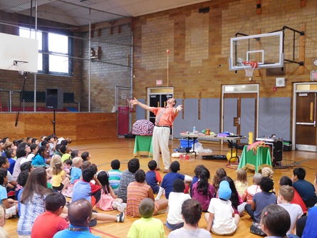 Audience gathered in the gymnasium watching Marvelous Marvin perform a balancing trick on his chin