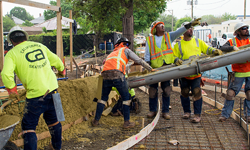 Several workers pouring concrete at the Fern Street public art site
