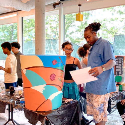 Artist Marlon Forrester (center right) works with teens.