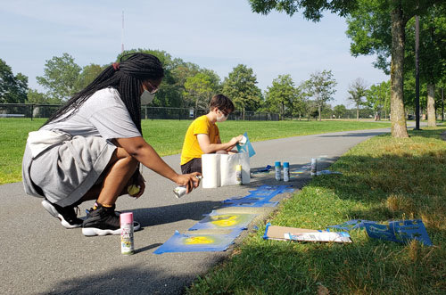 For their 2020 project "The Missing Unicorn," members of the Cambridge Arts Public Art Youth Council chalk-paint "You are entering the presence of a unicorn" on a park path.
