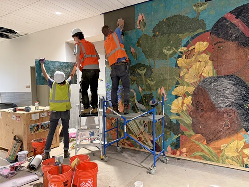 Installation view at Tobin Montessori and Darby Vassall Upper Schools and Community Complex. Members of Mosaika Art & Design install Amanda Phingbodhipakkiya’s “Worlds Stir in the Tender Shoots of Memory.” Photo by Cambridge Arts.