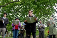 Singers perform Andy Graydon's "Gathering Note (a facsimile)" on Cambridge Common, May 13, 2017.