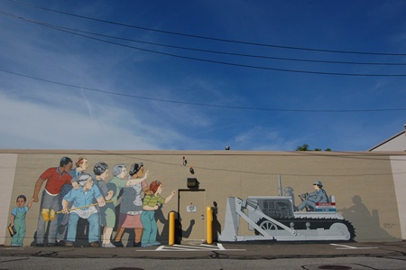 A show of the full stretch of the Beat the Belt mural on the side of the Microcenter building, fully repainted