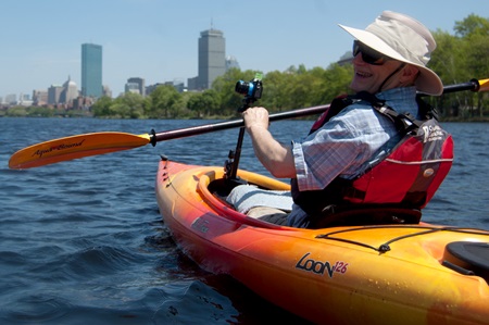The downtown Boston skyline opens up behind photographer Richard Hackel after he passes under the BU Bridge along the Charles River.
