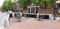 Empty tables and chairs in Harvard Square