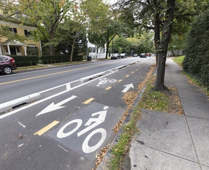 A two-bike bike facility on Brattle Street is separated from general traffic lanes with concrete curbing.