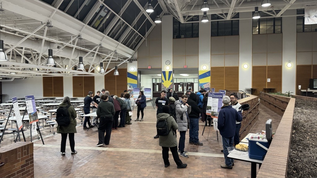 people standing around in a school cafeteria mingling 