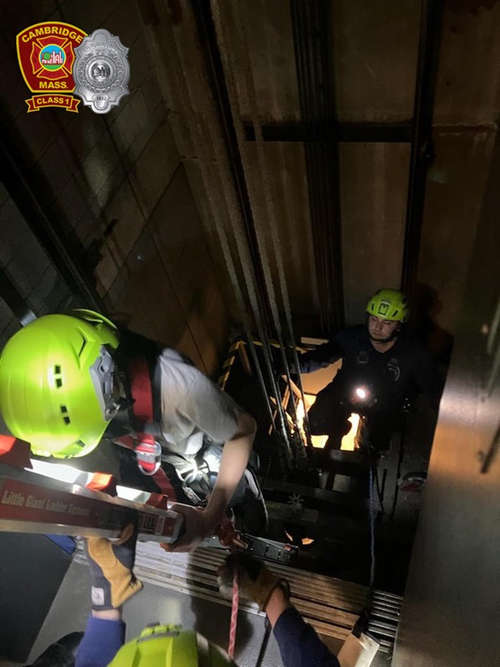 firefighters working in a blind elevator shaft to rescue a person trapped in a stalled elevator car