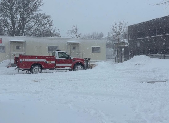 Fire apparatus Mechanic M4 plowing the snow from the apron and parking area of Station 10 on Hovey Av