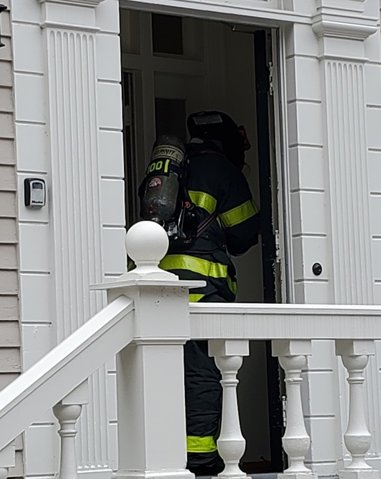 gas investigation firefighter in full PPE (persoanl protective equipment) enterint a residence