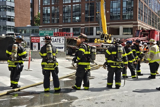 firefighters in full PPE (personal protective equipment) working at a commercial gas main investigation