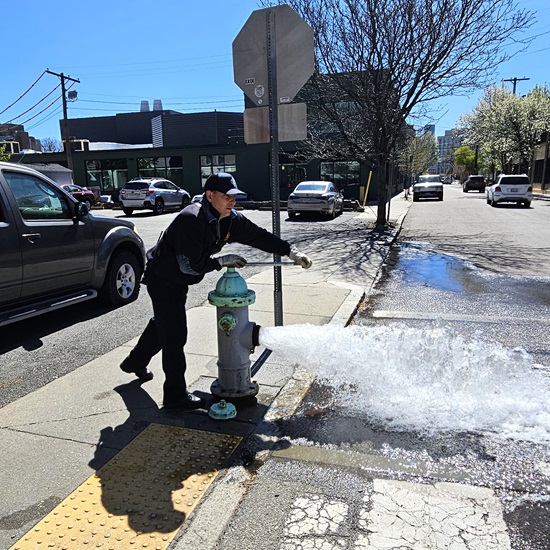 An Engine 6 firefighter fully flows the fire hydrant