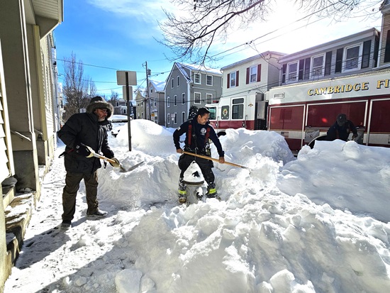 Cambridge Firefighters with help from a neighbor shoveling hydrants in East Cambridge