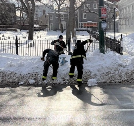 Ladder 1 firefighters shoveling snow from a hydrant