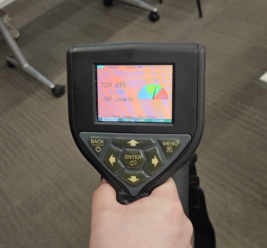 a hand held meter testing for radiation in the atmosphere.