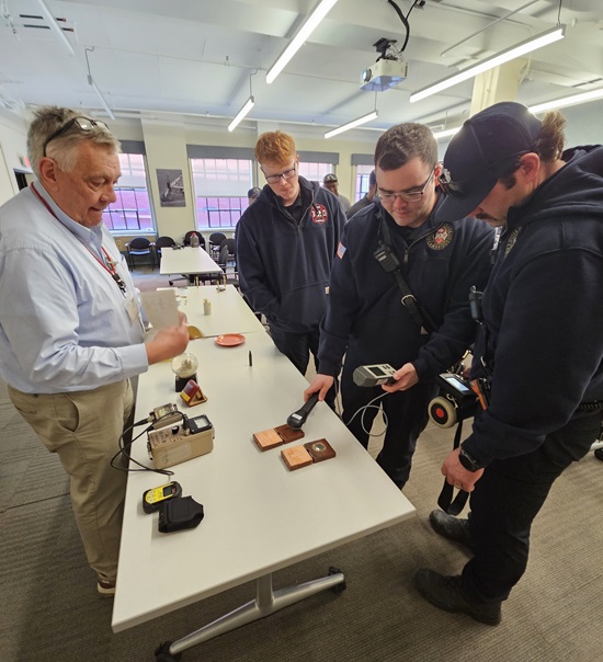 Under the guidance of MIT EHS staff, firefighers use various meters to detect radiation