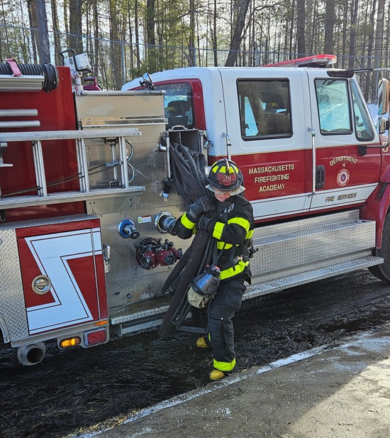 Recruit Firefighter stretching an attack line from the pump - MA Fire Academy recruit class burn training