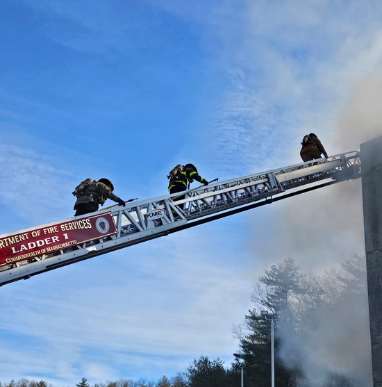 Reruit firefighters climbing the aerial ladder at MA Fire Academy burn training building