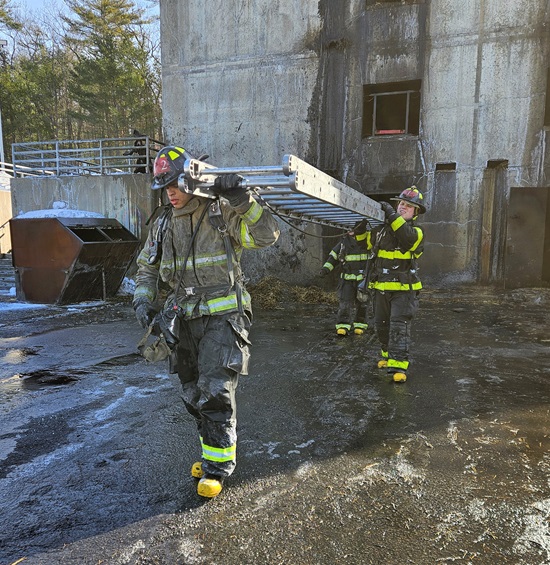 Recruit firefighters carrying a ground ladder at MA Fire Academy burn building - Stow, MA