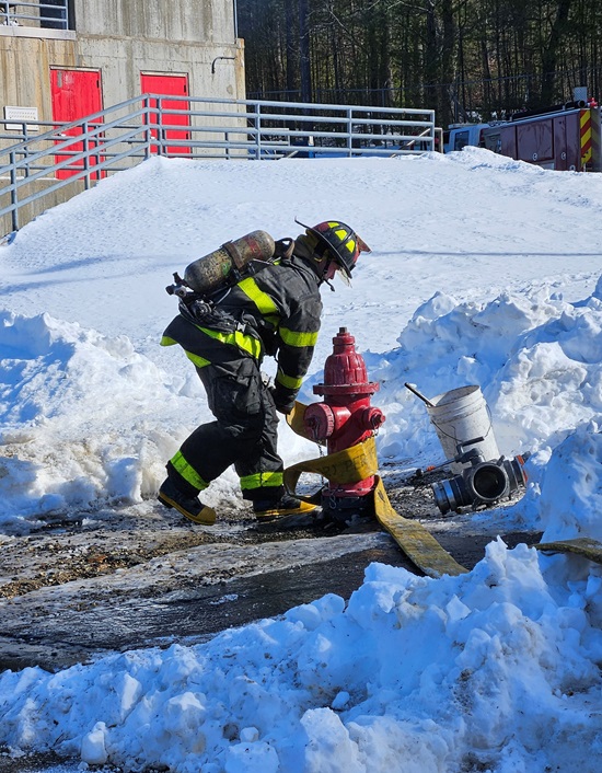 Recruit Firefighter establishing a water supply from the hydrant at MA Fire Academy burn training