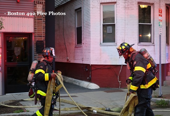 Firefighters of Engine 3 stretch an attackline at the working fire, 803 Cambridge St