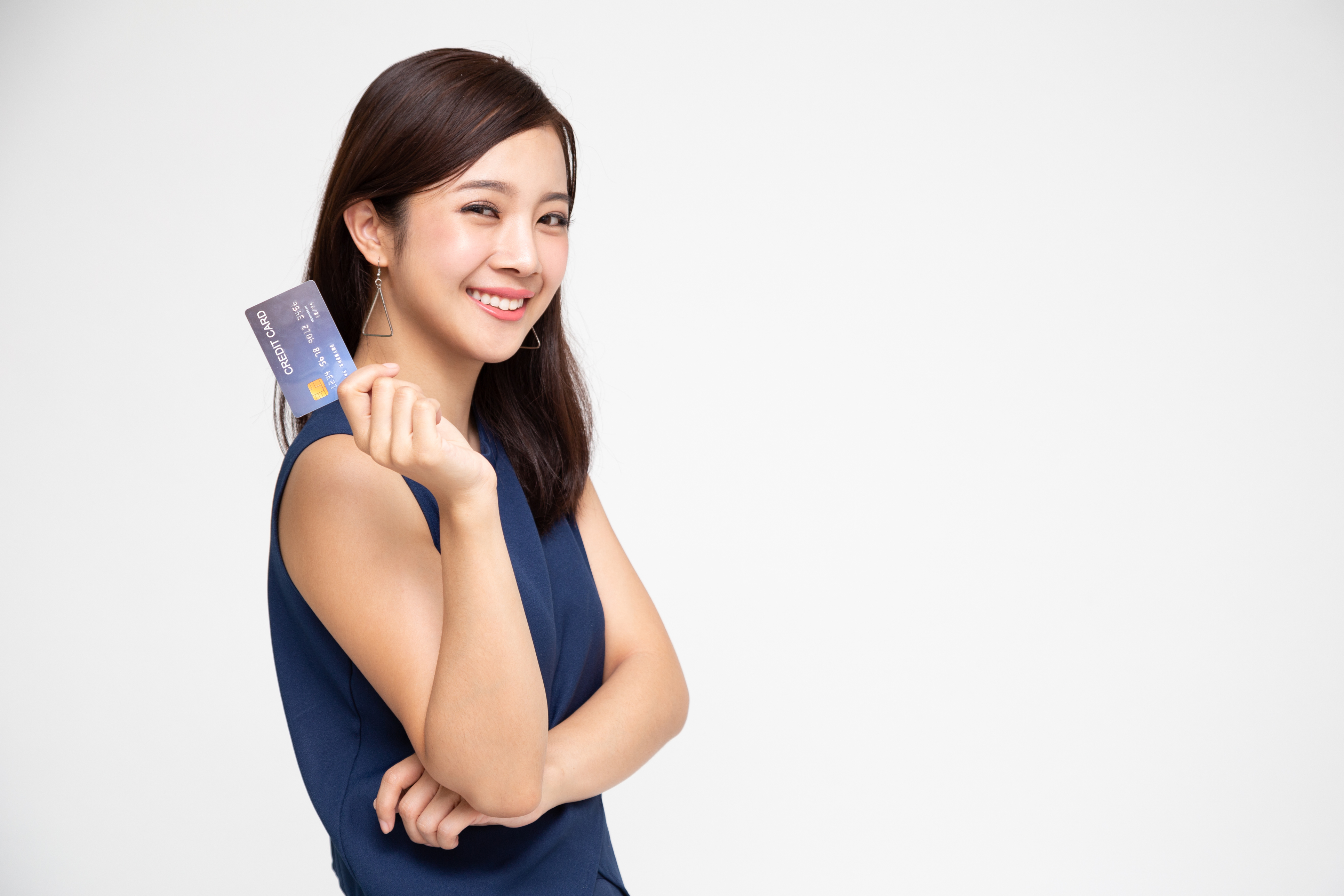 A woman smiling and holding a credit card