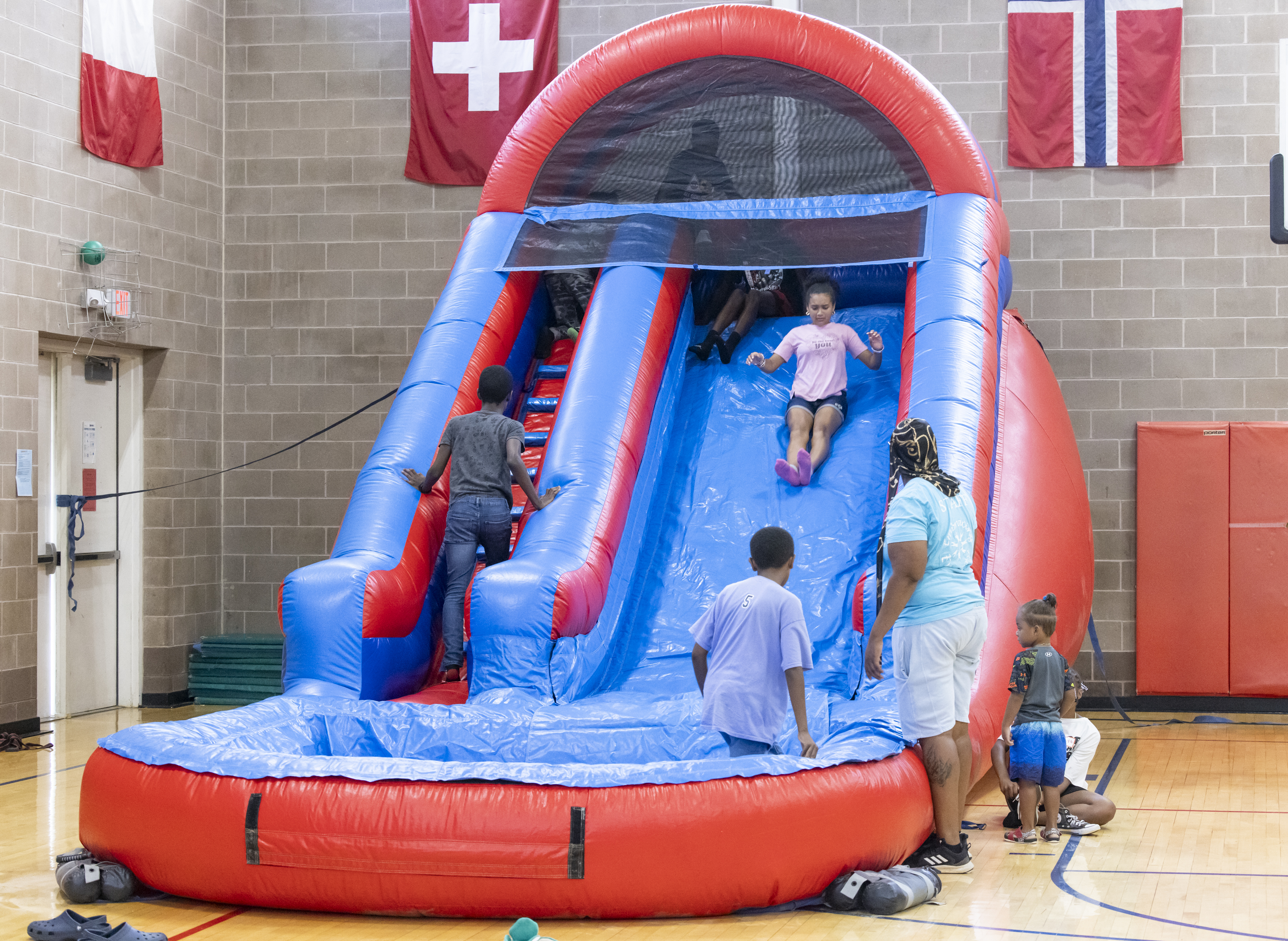 A group of youth engaged in an indoor activity with an inflatable slide and pool