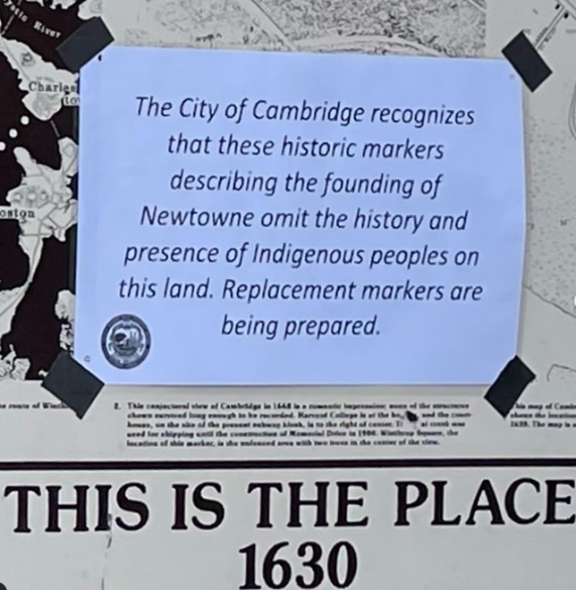 Winthrop Park sign stating "The City of Cambridge recognizes that these historic markers describing the founding of Newtowne omit the history and presense of Indigenous peoples on this land. Replacement markers are being prepared.