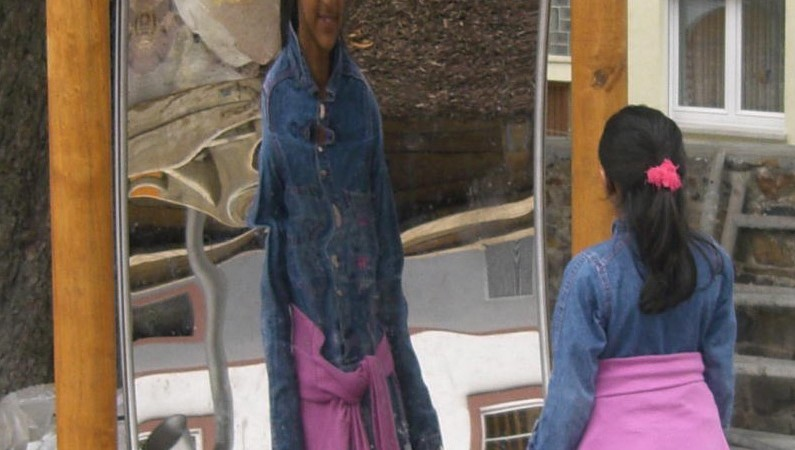 Girl looking at her reflection in a Distortion Mirror