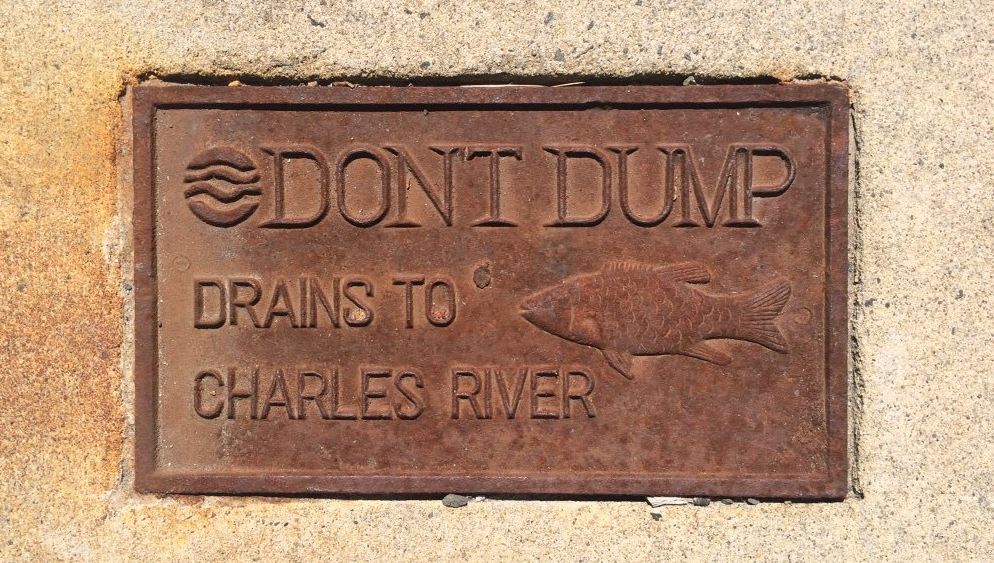 Sign on sidewalk saying don't dump - drains to charles