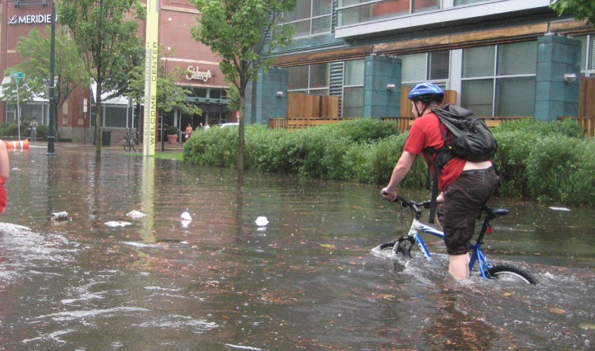 Man riding bicycle through flooded street