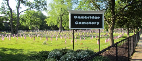 Cambridge Cemetery sign with american flags on each grave marker