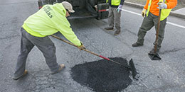 Photo of workers filling a pothole
