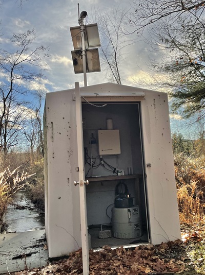 A shed next to a tributary with equipment for automatic collection of water quality samples.