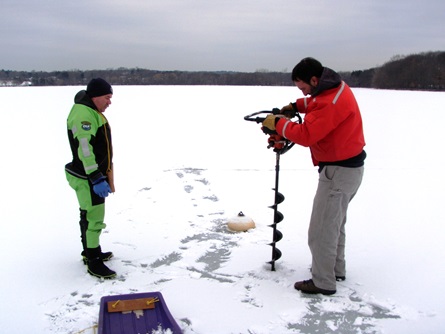 CWD staff starts to drill a hole through the ice while Fire Department staff watches for safety.