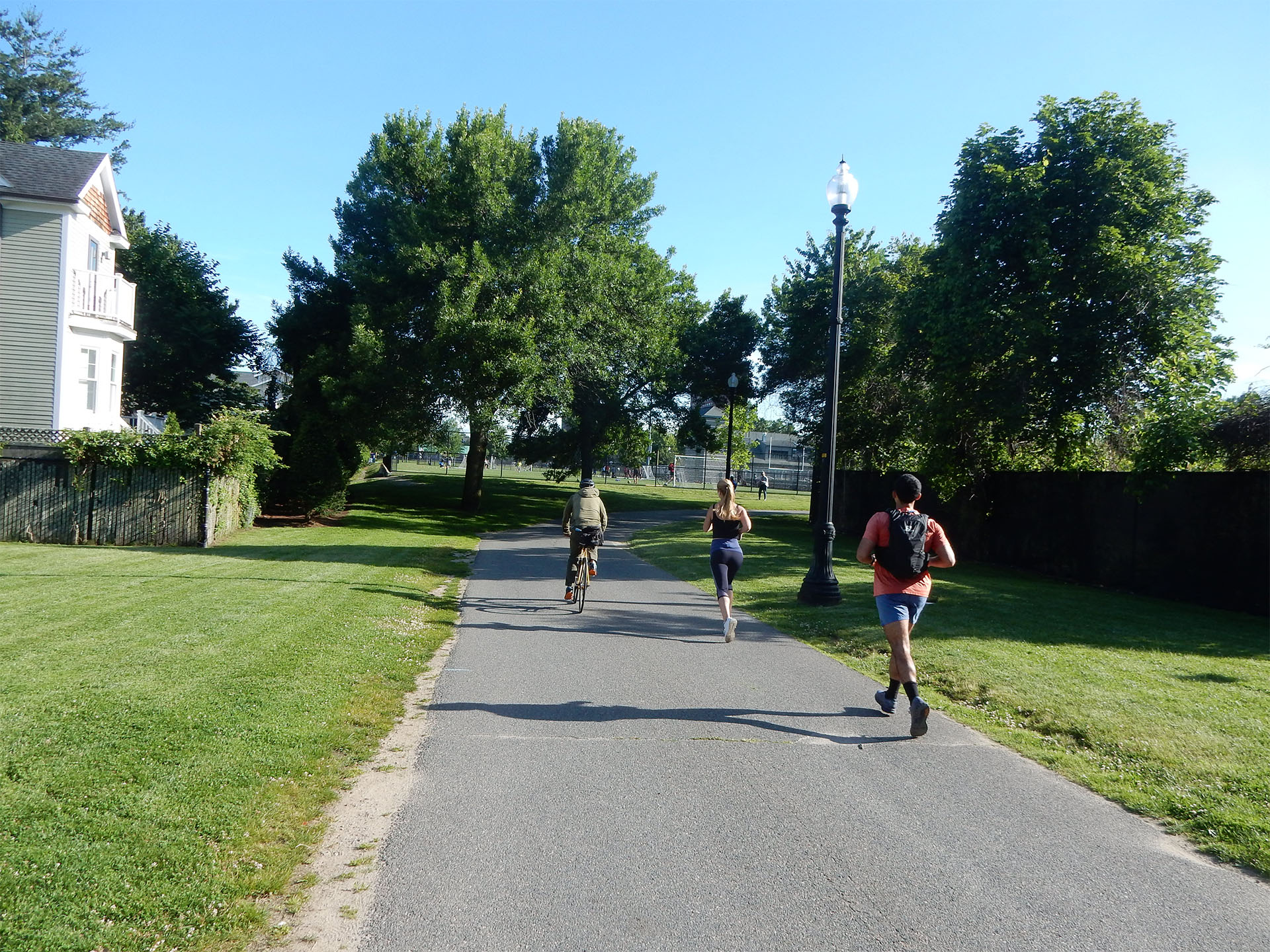 Runners and a bicyclist using Linear Park on a sunny day