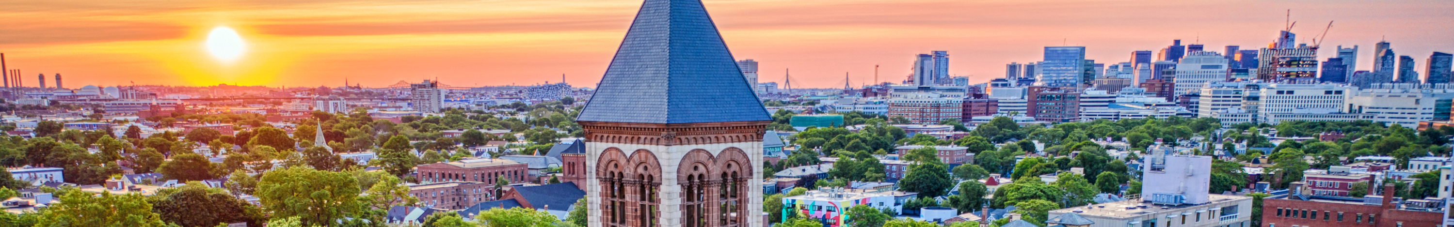 Aerial photo of Cambridge and Boston at sunrise with the City Hall bell tower in the foreground