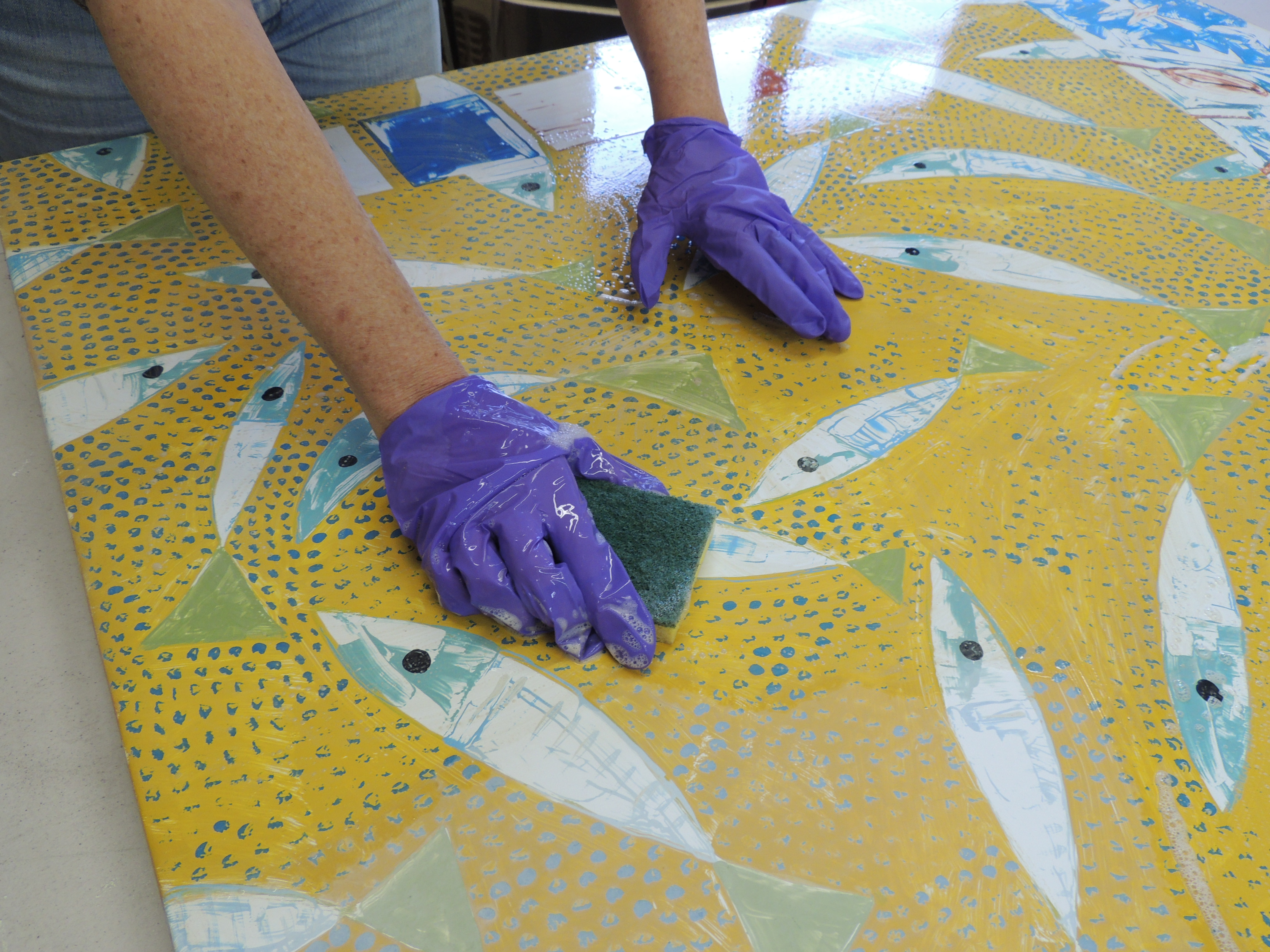 Lisa Houck's mural, "The Bluefish is Good Tonight," installed in Inman Square, is getting treated in the artist's studio.