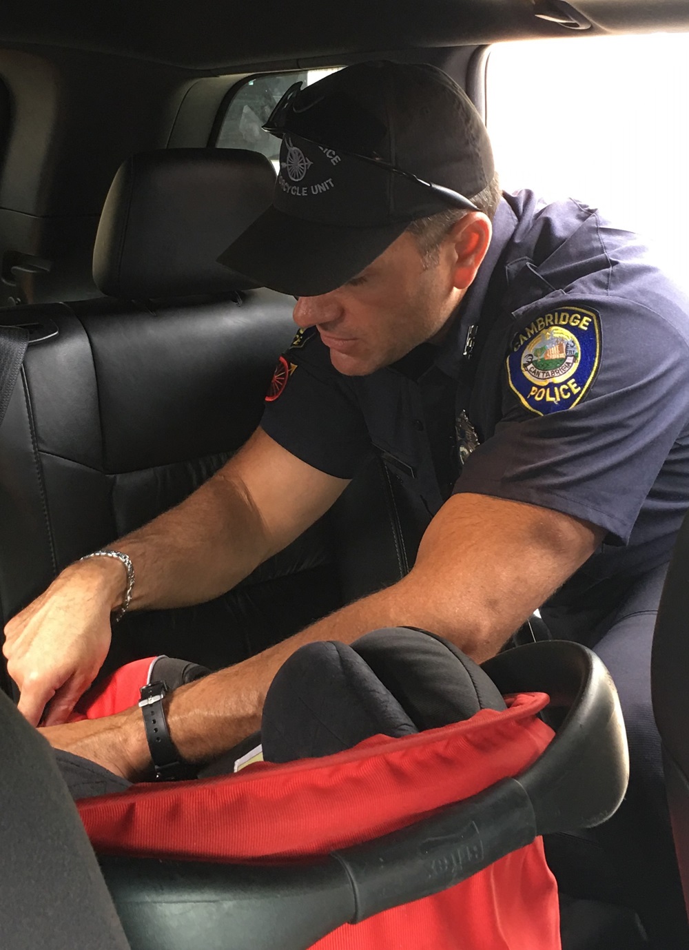 A safety officer carefully inspects a child safety car seat to ensure it is properly installed in the vehicle.