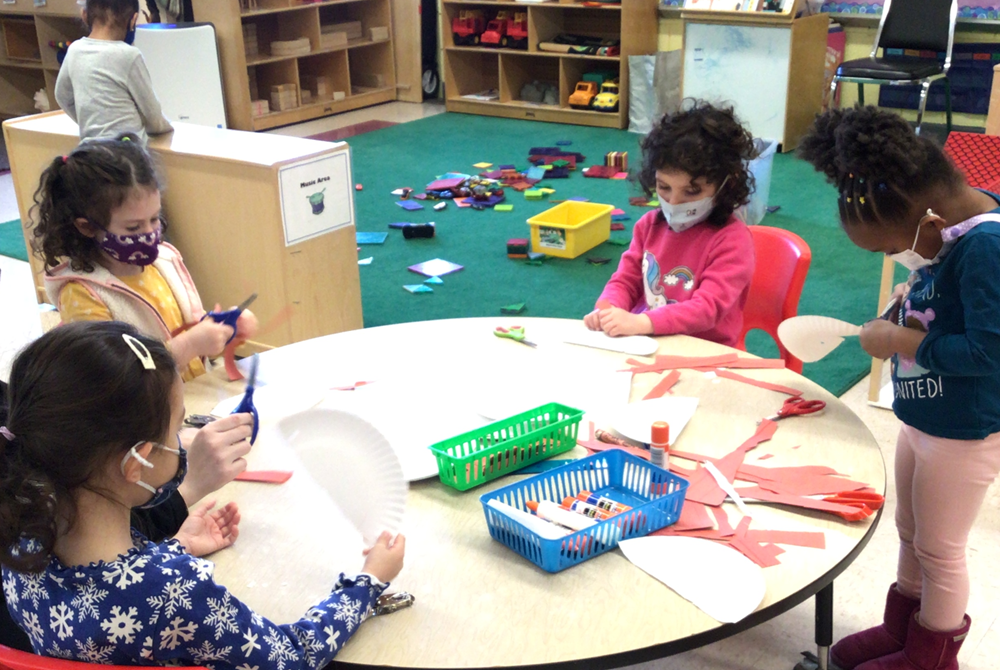 Photograph of young children taking part in an arts and craft activity at a round table