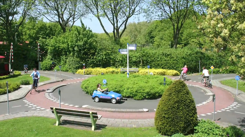 Rotary at a traffic garden with children playing in a toy car