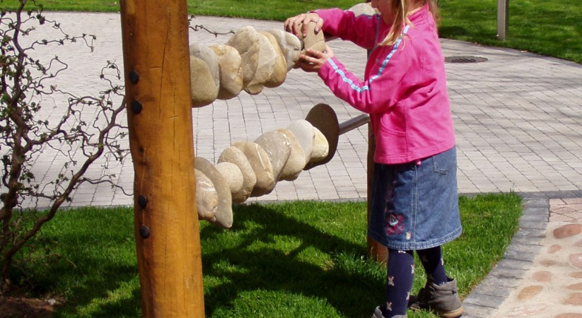 Child playing with a Stone Abacus