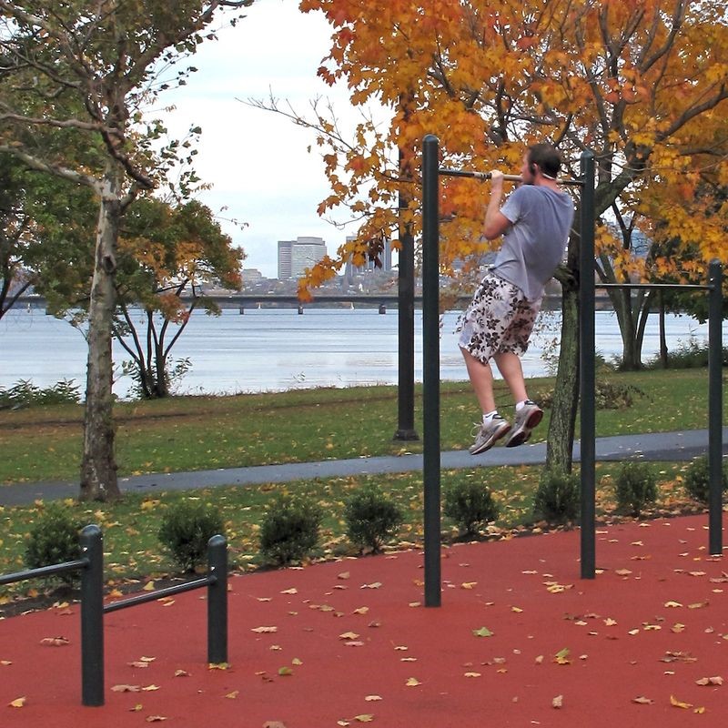 Man doing pull-ups at outdoor exercise station