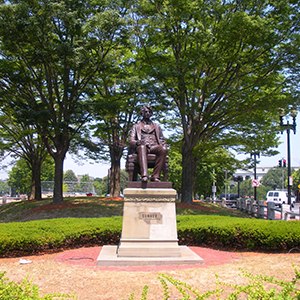 Statue of Gate Sumner in park with trees in background