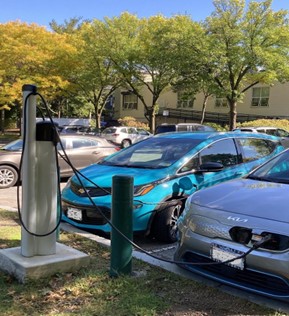 Two electric cars plugged into charging station