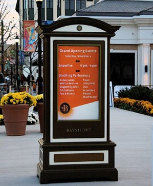 A sign in a plaza with a schedule of that day's events.