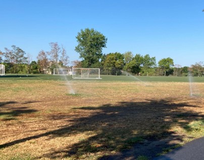 Danehy park soccer fields. There are trees in the background, and in the foreground there are shadows indicating that there are trees immediately behind the person taking the picture.